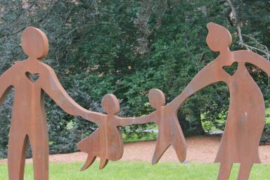 The multi-generational sculpture stands outside of NewBridge on the Charles 