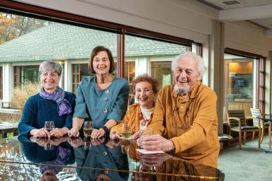 Orchard Cove residents standing by a piano