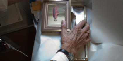 A woman places her hands over a few picture frames.