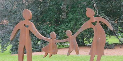 The multi-generational sculpture stands outside of NewBridge on the Charles 