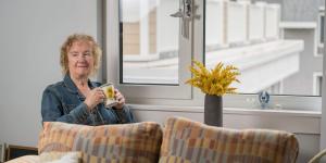 Woman sitting by a window with a mug