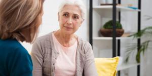 Older woman sitting with another woman