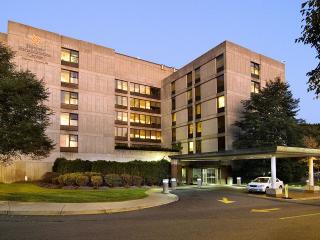 Hebrew Rehabilitation Center at dusk, with white car pulling into horseshoe driveway at entrance.