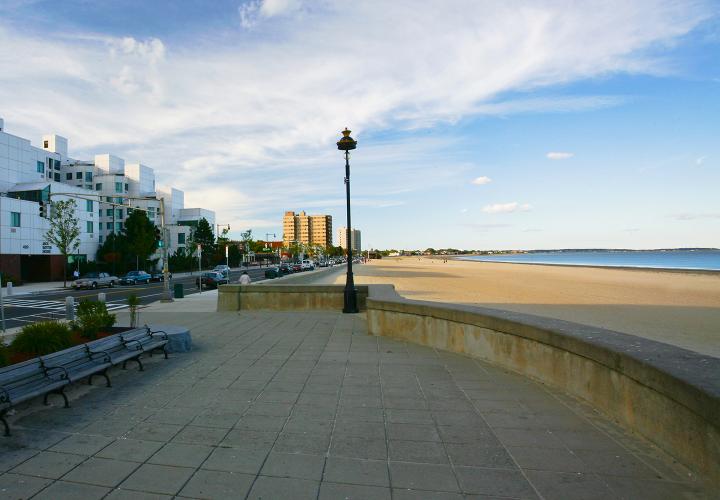 Exterior of Jack Satter House showing long strip of sandy Rever Beach and ocean water.