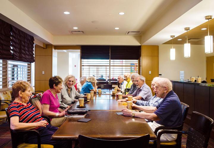 A group of NewBridge residents enjoy coffee and conversation following a theatrical performance in Great Meadow Hall.