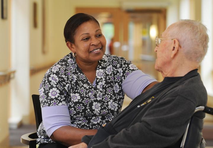 Smiling staff with older adult in wheelchair at Hebrew Rehabilitation Center