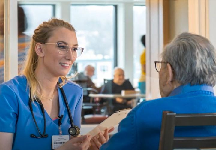 A therapist smiles as she talks to a Hebrew Rehabilitation Center patient.